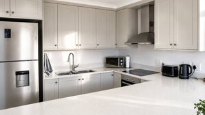 A modern kitchen with stainless steel appliances, a built-in oven, and a microwave.