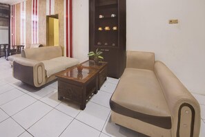 Una sala de estar con dos sofás, una mesa de centro y un aparador con objetos decorativos.