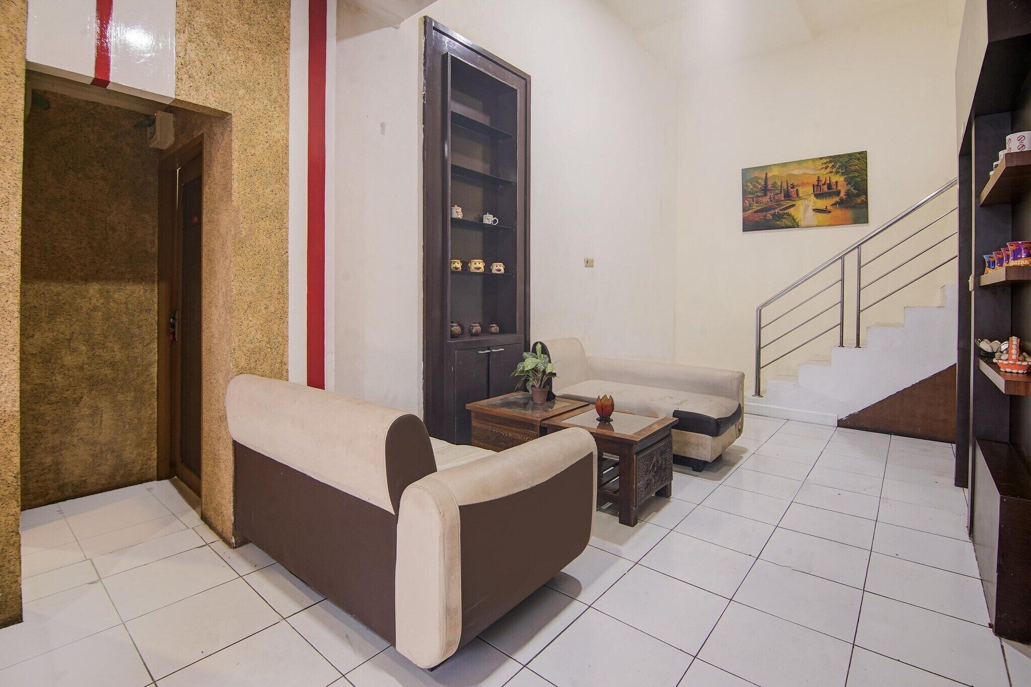 Un salon comprenant un canapé, une table basse, un meuble et un escalier.