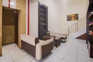 A living room with a sofa, a coffee table, a cabinet, and a staircase.
