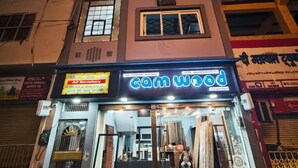 A multi-story building with a storefront named 'Cam Wood' at the ground level. - Khushi Home Stay (Varanasi)