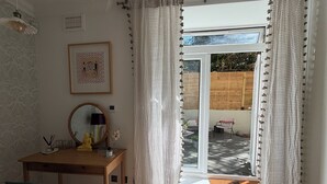 Ein Zimmer mit einem Holztisch, einem Stuhl, einem Spiegel und einem gerahmten Bild an der Wand.