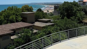 A coastal view with a beach, a pier, and a building with a balcony overlooking the sea. - Brand-New Sea View in Vasto Marina with Parking (Marina di Vasto)