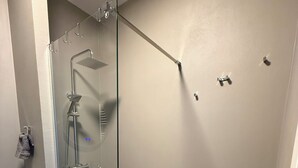 A modern bathroom with a glass-enclosed shower, a toilet, and a sink. - Brand-New Sea View in Vasto Marina with Parking (Marina di Vasto)