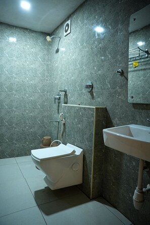 Un baño con inodoro, ducha y lavamanos.