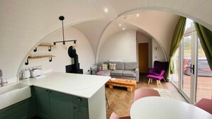 Un espacio habitable compacto con cocina, comedor y asientos.
