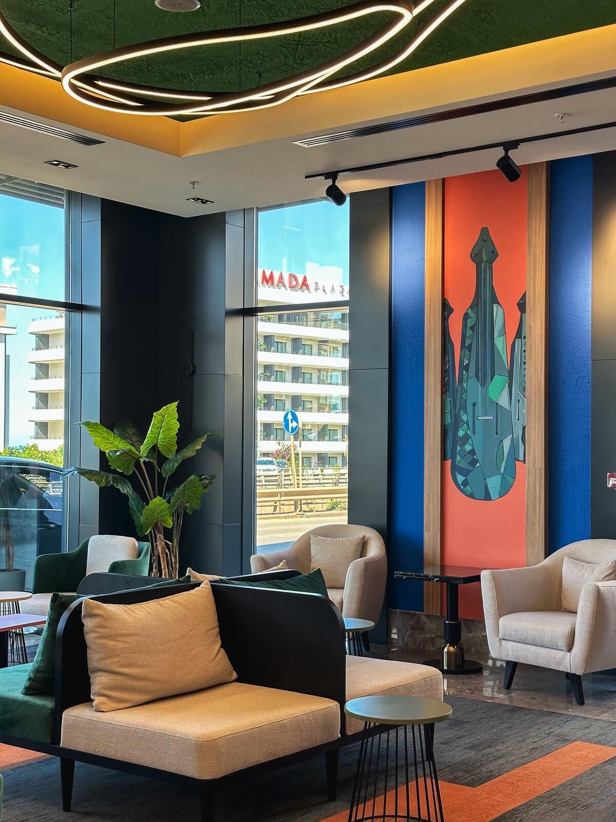 A modern lobby with seating, a large window, and a cityscape view.