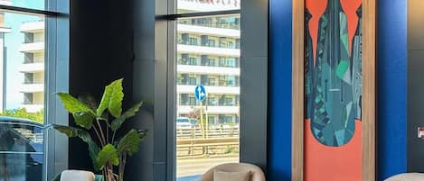 A modern lobby with seating, a large window, and a cityscape view.