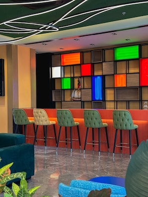 A modern lobby with a bar area, seating, and a decorative wall. - Axis Hotel (Trabzon)