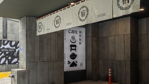 A hotel entrance with a sign indicating a sauna and a restaurant. - Cave Ryokan Hotel by Anook Seoul Jongno (Seoul)