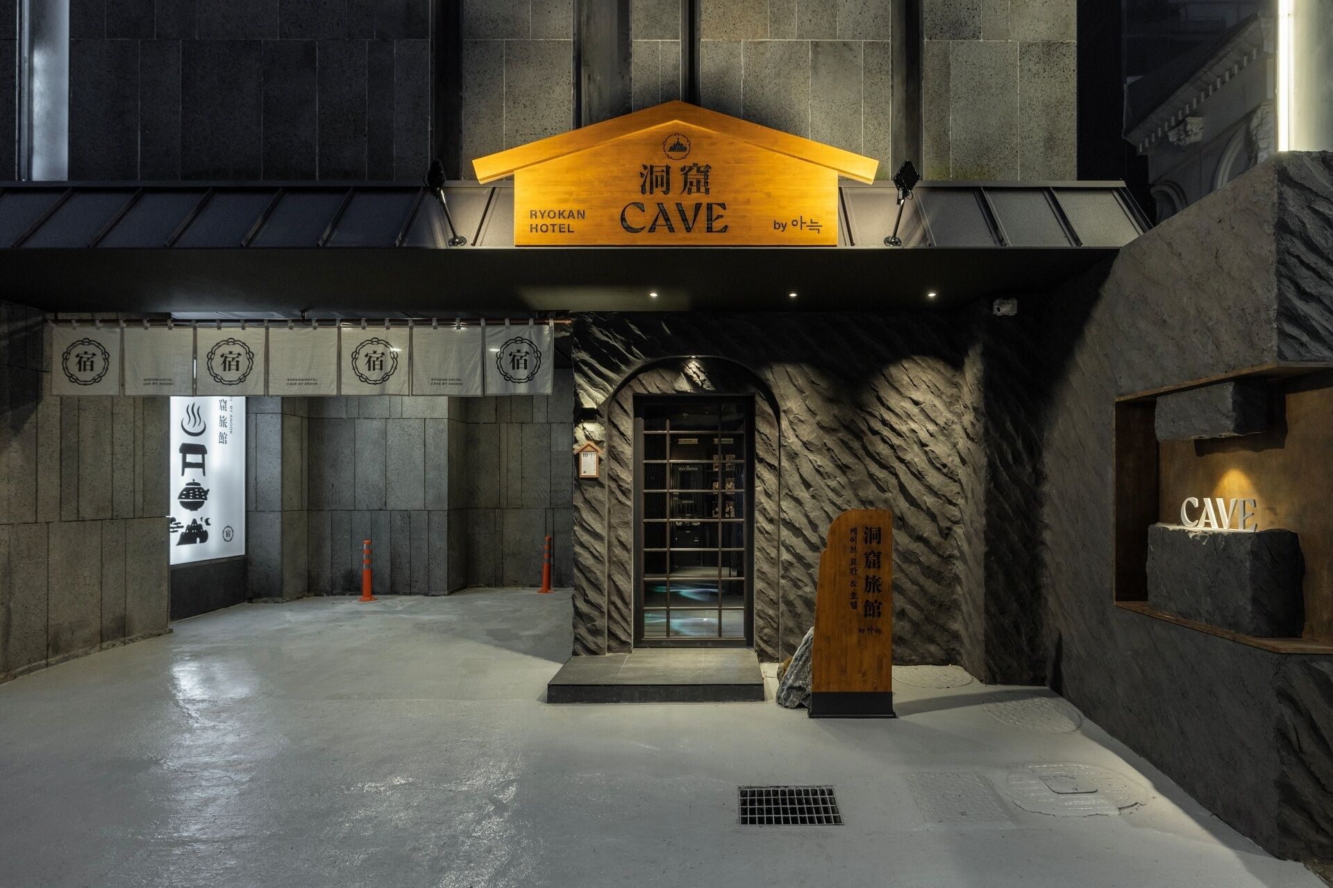 L’entrée du Ryokan Cave Hotel, avec sa façade rappelant une grotte et son panneau indicateur.