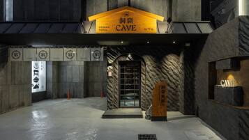 L’entrée du Ryokan Cave Hotel, avec sa façade rappelant une grotte et son panneau indicateur.