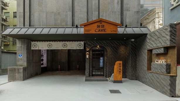 A hotel entrance with a stone facade, a wooden sign above the door, and a tiled pavement in front. - Cave Ryokan Hotel by Anook Seoul Jongno (Seoul)