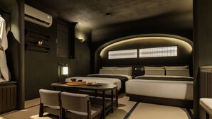 A hotel room with a large bed, a smaller bed, a desk with chairs, and a window with bars. - Cave Ryokan Hotel by Anook Seoul Jongno (Seoul)