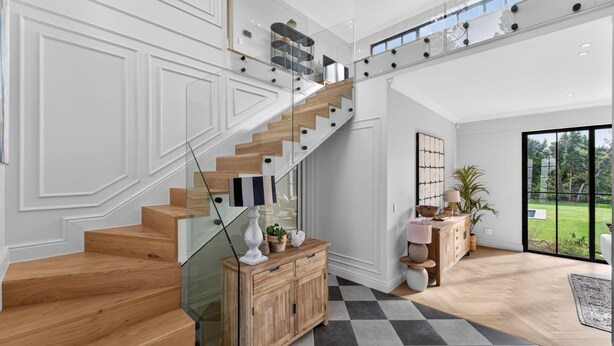 A modern interior with a wooden staircase, a glass railing, and a view of the outdoors. - Belle Grove (Cape Town)