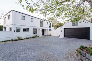Ein modernes, zweistöckiges Haus mit gepflasterter Auffahrt und Garage.