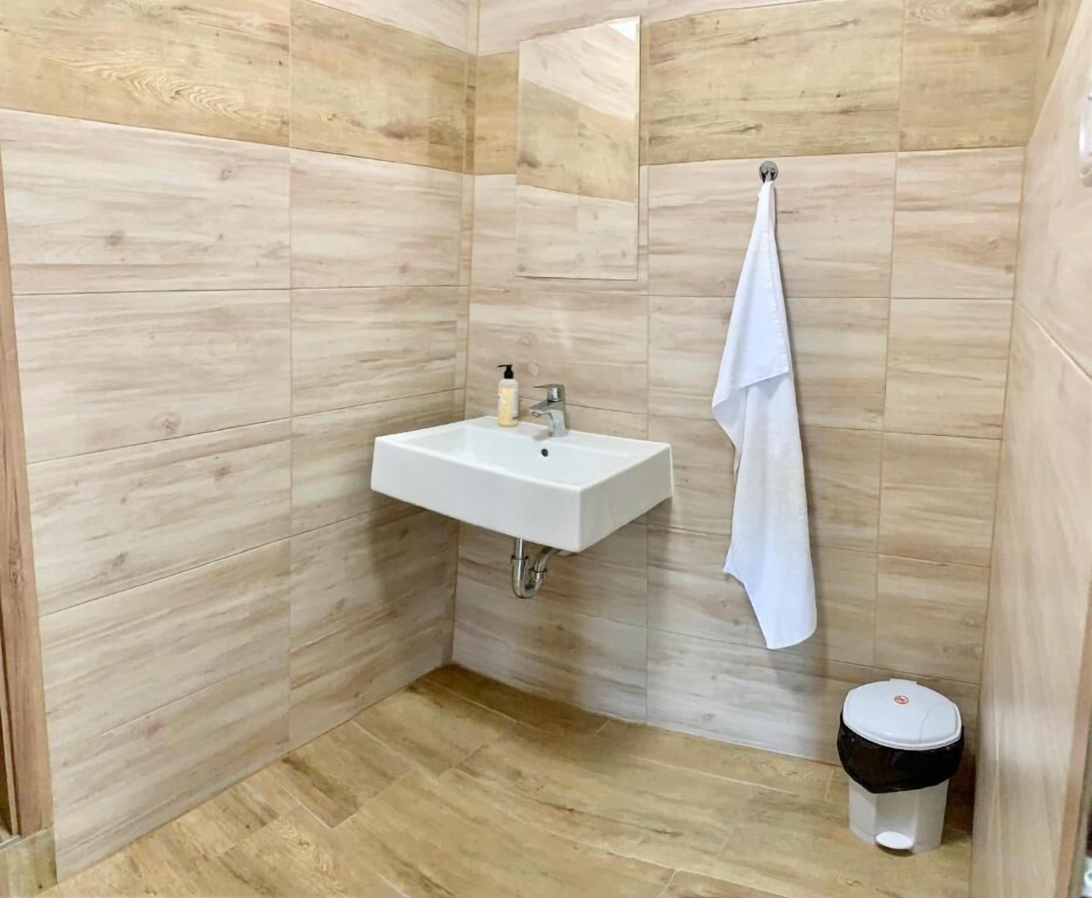 Un baño con lavamanos, toallero y retrete.