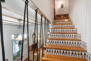 A staircase with a wooden finish and decorative tiles featuring tree patterns.