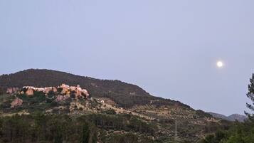 A mountainous landscape with a clear sky and a visible moon.