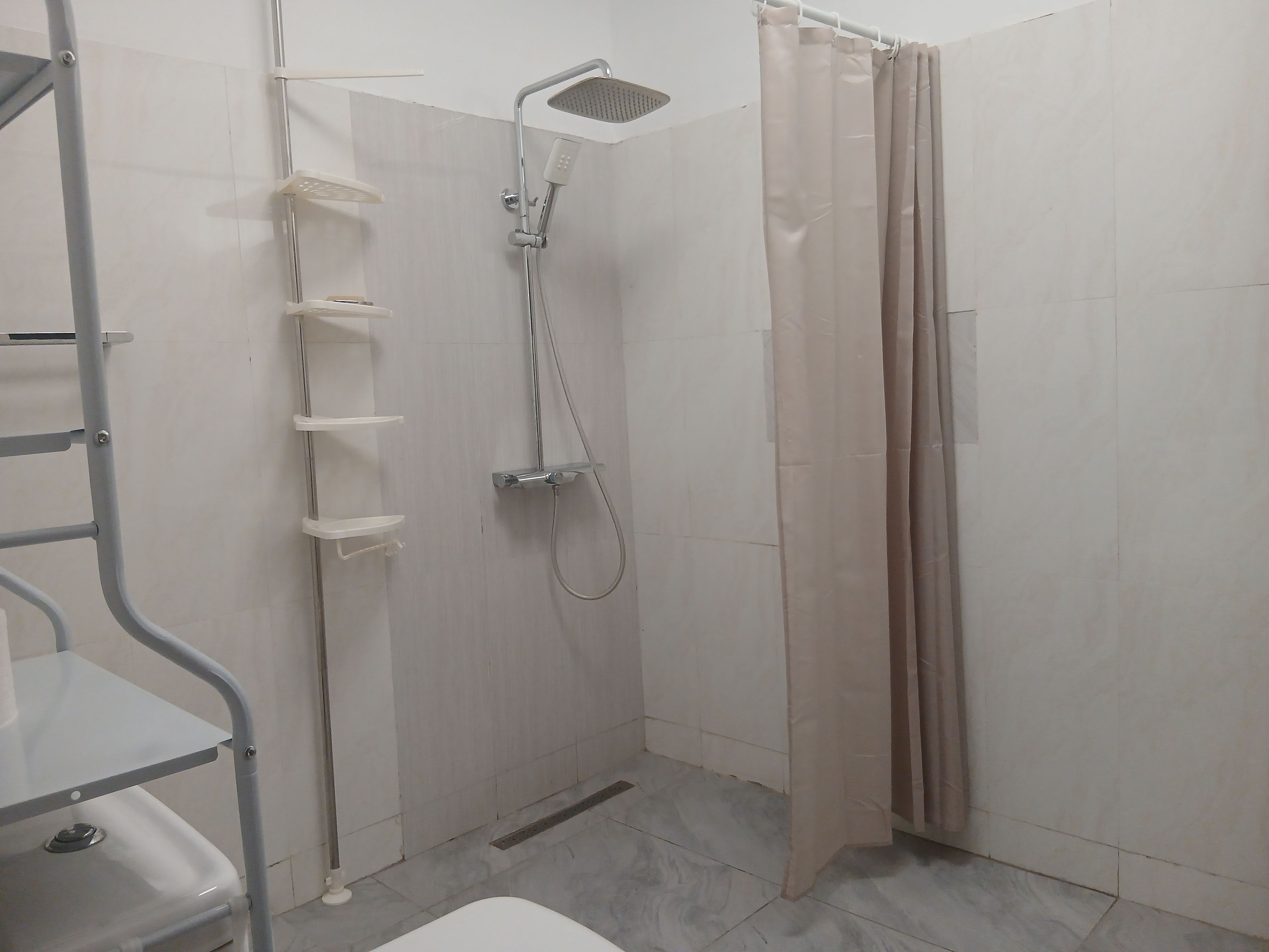 Un bagno con doccia, WC e pensile.