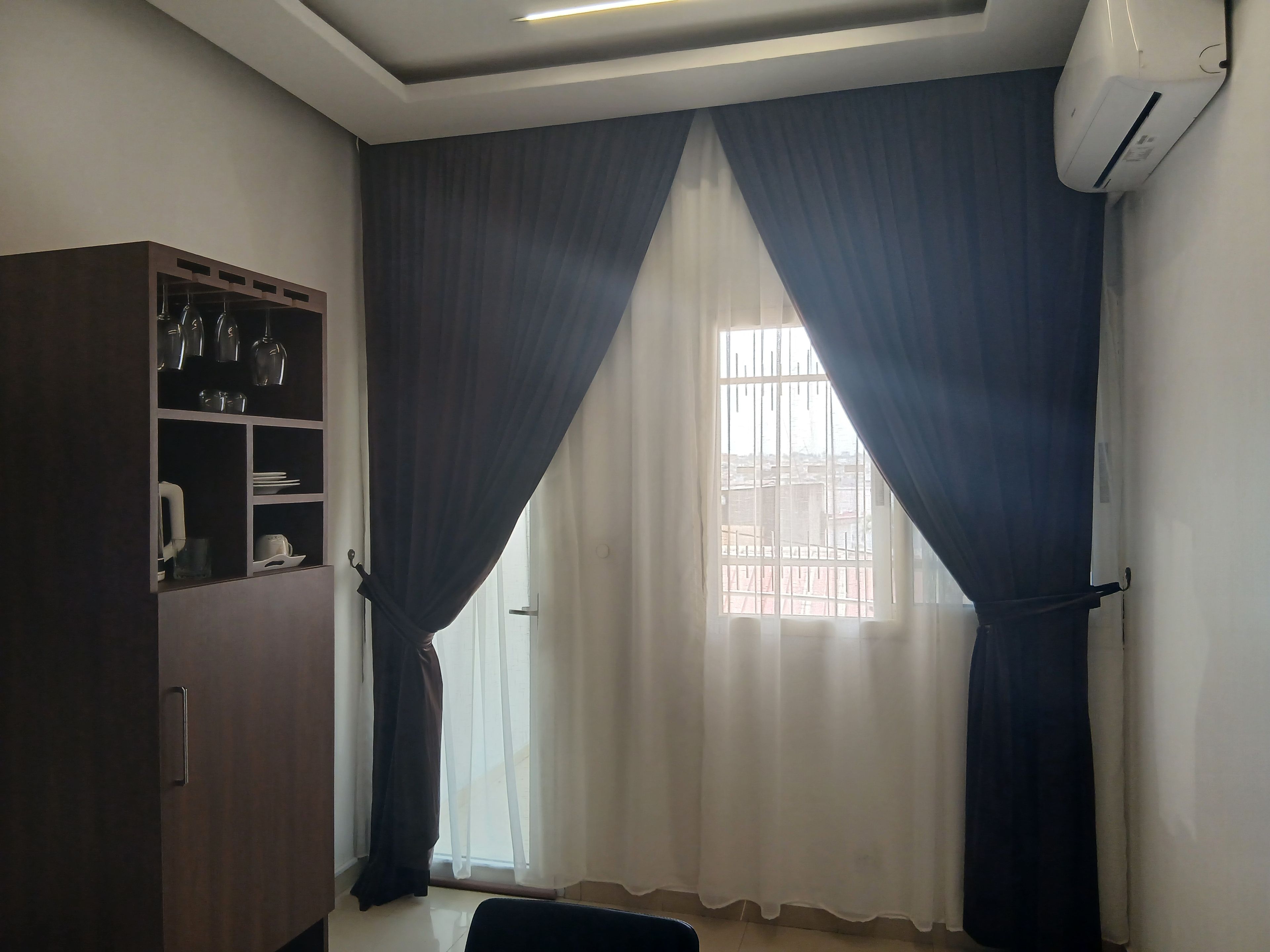 Una habitación con ventana, armario y aire acondicionado.