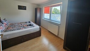 Un dormitorio con cama, un radiador, una ventana con persiana y una puerta.