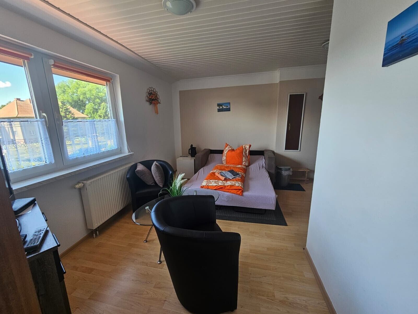 Ein Hotelzimmer mit Bett, Sessel, Schreibtisch und Fenster mit Aussicht.