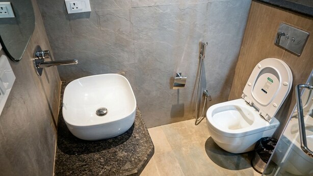 Un baño moderno con lavamanos blanco, inodoro y ducha.