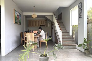 A home interior with a dining area, staircase, and potted plants. - Modern Suite Near Sanur Beach (Bali)