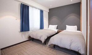 Habitación de hotel con dos camas individuales, un ventanal grande con cortinas azules y suelo alfombrado.