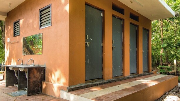 A building with a single bathroom featuring a sink and two doors. - Parampara Cottages (Haliyal)