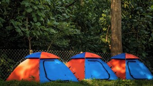 Three tents with a chain-link fence in the background. - Parampara Cottages (Haliyal)