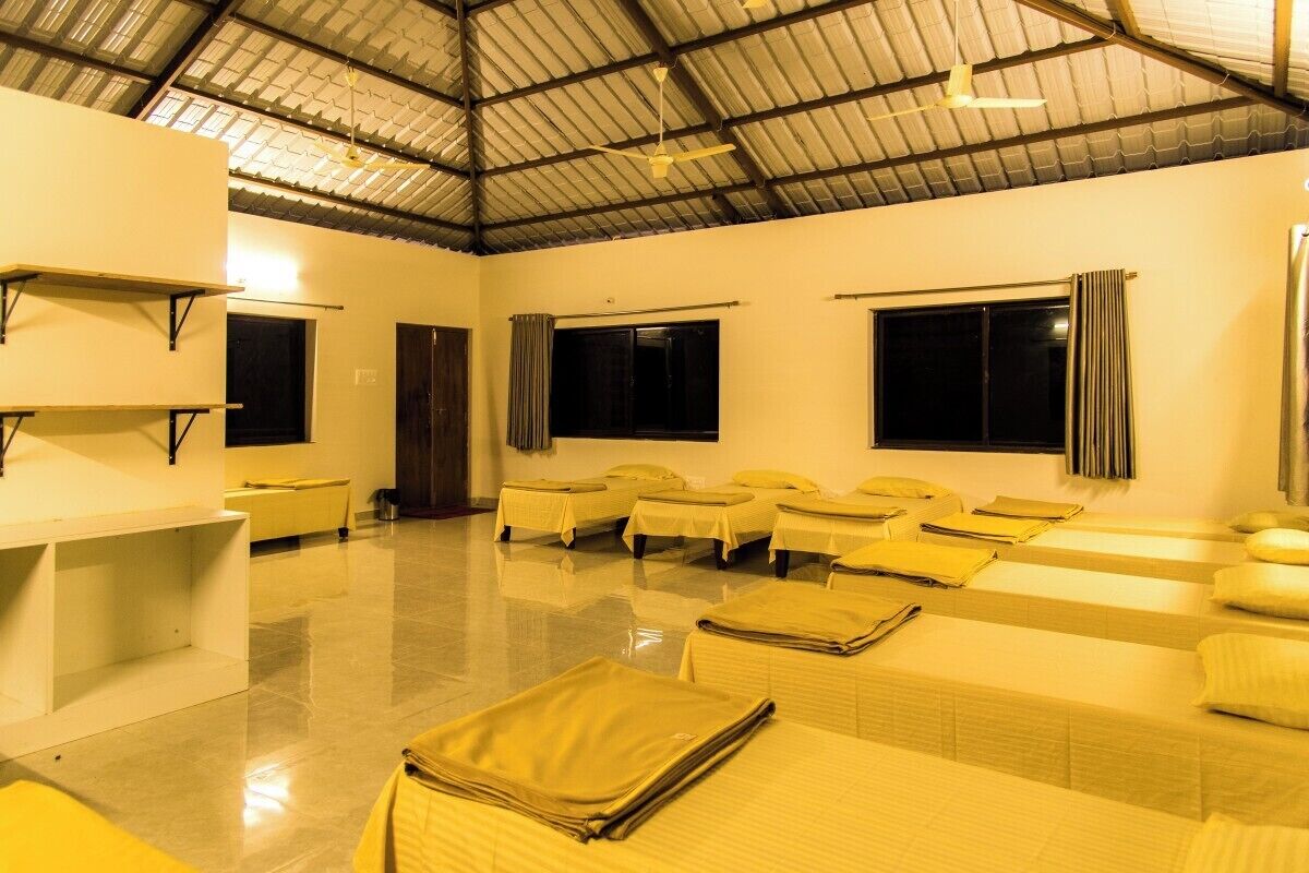 Habitación de hotel con varias camas, un ventanal grande y un ventilador de techo.