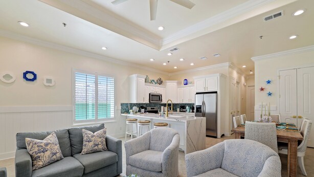 A modern living room with a grey sofa, two armchairs, and a dining table with chairs. - 2-bedroom 2-bathroom condo in South Padre Island with AC
2 minute walk to beach (South Padre Island)
