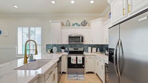 A modern kitchen with white cabinetry, stainless steel appliances, and a marble countertop. - 2-bedroom 2-bathroom condo in South Padre Island with AC
2 minute walk to beach (South Padre Island)