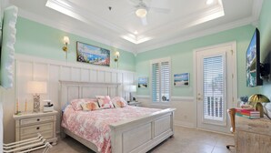 A bedroom with a bed, nightstands, a dresser, and a television. - 2-bedroom 2-bathroom condo in South Padre Island with AC
2 minute walk to beach (South Padre Island)