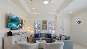 A living room with a television, sofas, and a ceiling fan. - 2-bedroom 2-bathroom condo in South Padre Island with AC
2 minute walk to beach (South Padre Island)