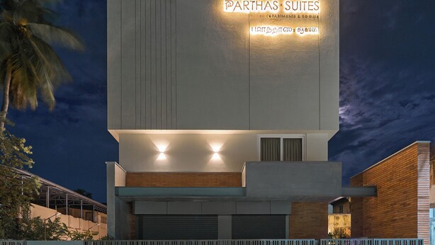 A modern building with a sign reading 'PARTHAS SUITES' and a gated entrance. - Parthas suites (Tiruchirappalli)