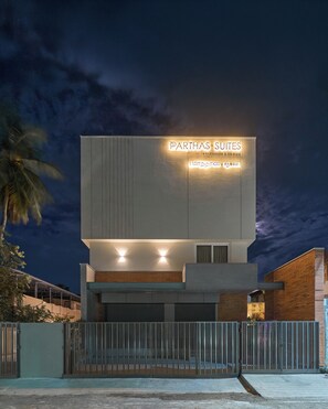 A modern building with a sign reading 'PARTHAS SUITES' and a gated entrance. - Parthas suites (Tiruchirappalli)