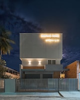 A modern building with a sign reading 'PARTHAS SUITES' and a gated entrance.