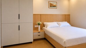 A bedroom with a bed, nightstand, and wardrobe.