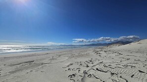 A beach with sand dunes and a clear sky.