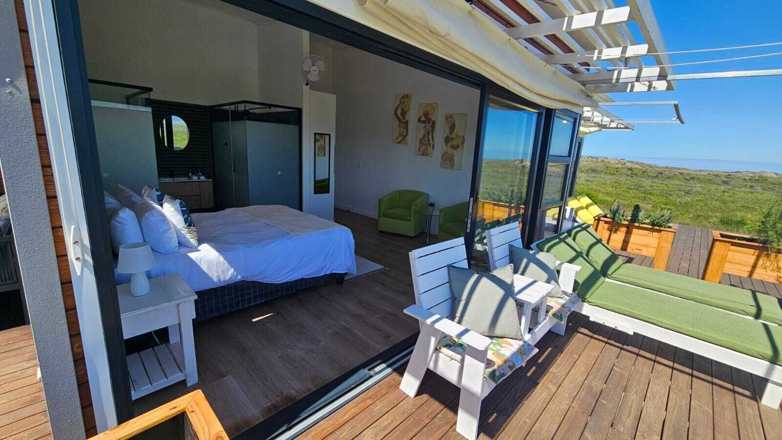 Ein Schlafzimmer mit einem Bett, einem Nachttisch und einem Fenster mit Blick auf eine Landschaft.