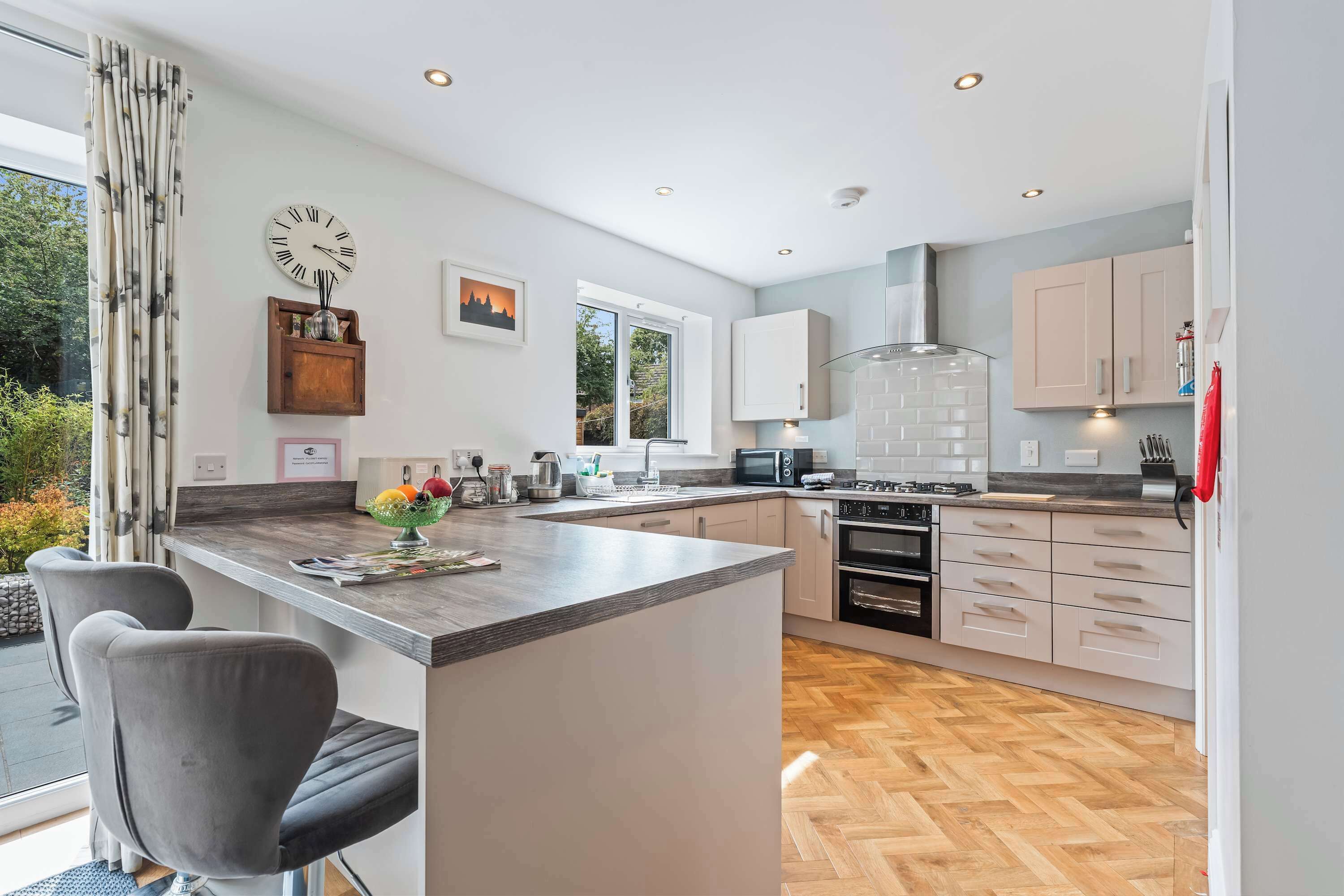 A modern kitchen with a central island, built-in appliances, and a view to the outdoors.
