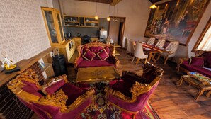 Une pièce comprenant un coin repas, un bar et un grand tableau accroché au mur.