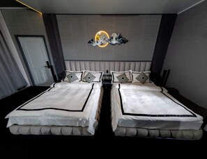 A double bed with a headboard, two decorative pillows, and a wall-mounted clock. - Mahaeliya Rock Castle (Nuwara Eliya)