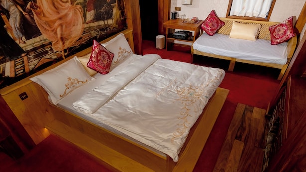 Ein Doppelbett mit Holzrahmen und rotem Teppichboden.