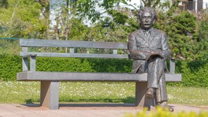 Un banc sur lequel est posée une statue représentant une figure assise.