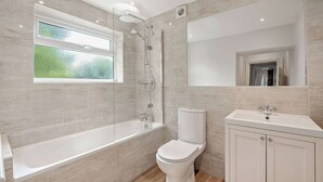 Ein modernes Badezimmer mit einer Glasdusche, einer Toilette und einem Waschbecken.