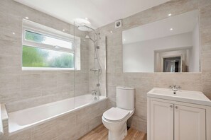 A modern bathroom with a glass-enclosed shower, a toilet, and a sink. - The Lodge (Leominster)